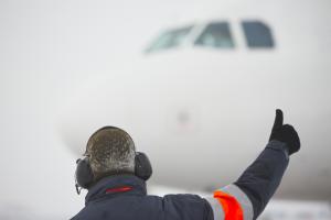 Member of ground crew is showing OK sign to pilot - selective focus