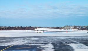 Passenger plane goes on snowy runway field. Turku airport in winter, Finland